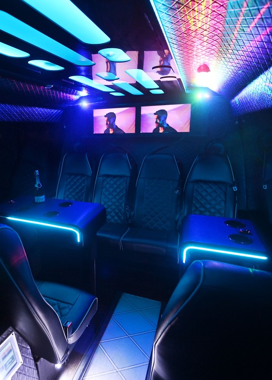 VIP Buses 2010 Mercedes Sprinter 16 Seater Party Bus rear bench and lit tables with a bottle