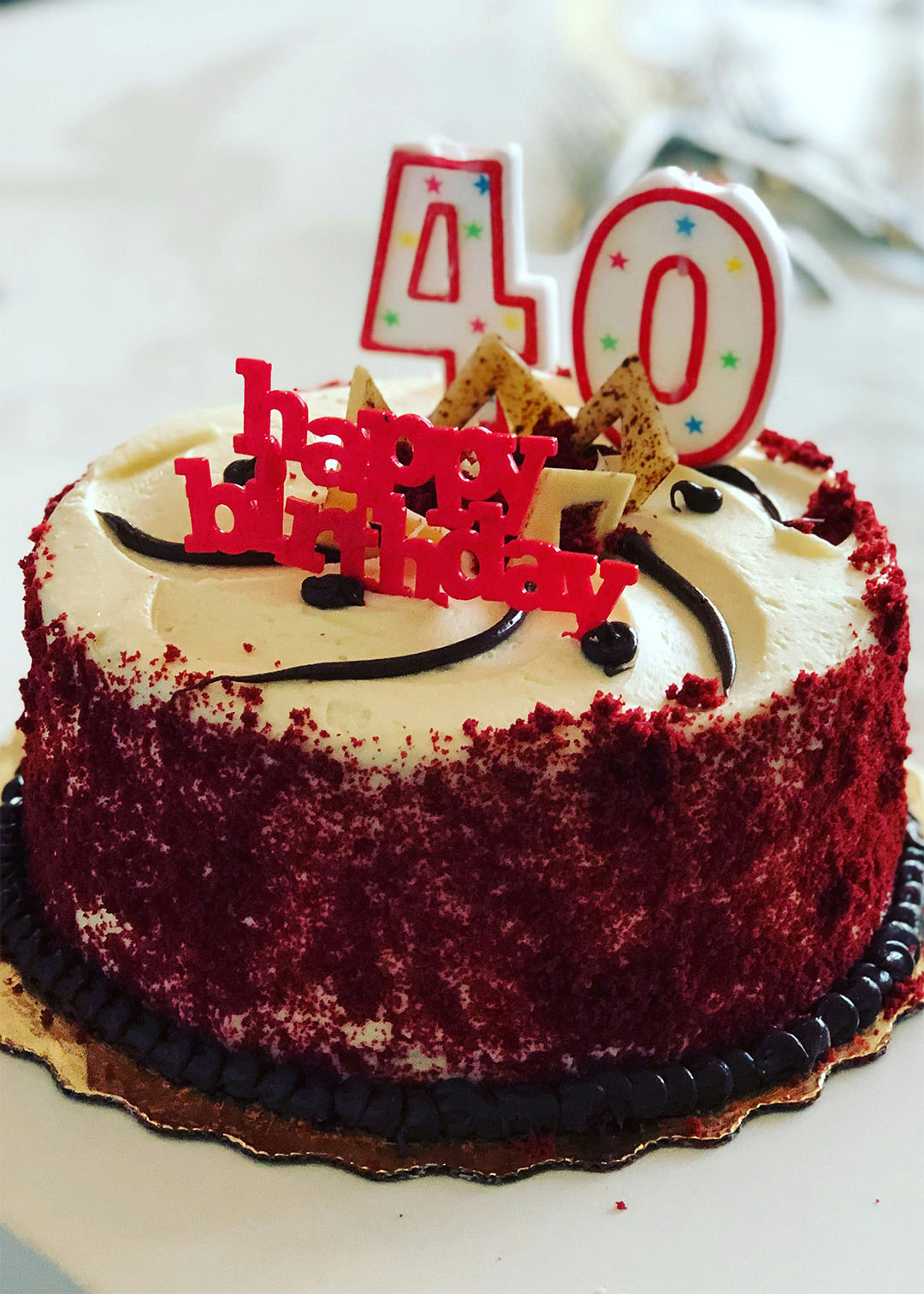 40th birthday party red velvet cake with candles and a happy birthday topper
