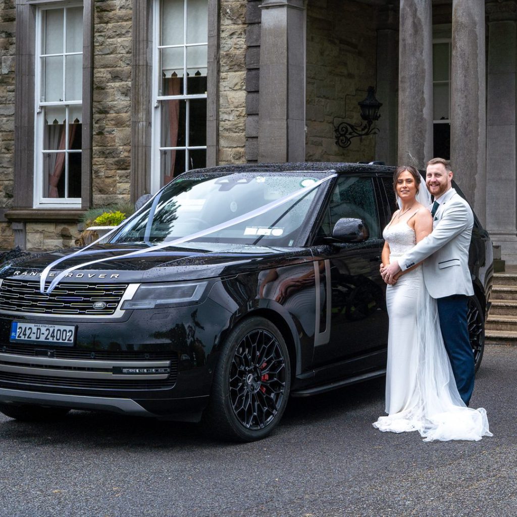 VIP Buses Black Range Rover Vogue SWB with the couple embracing beside the entrance steps