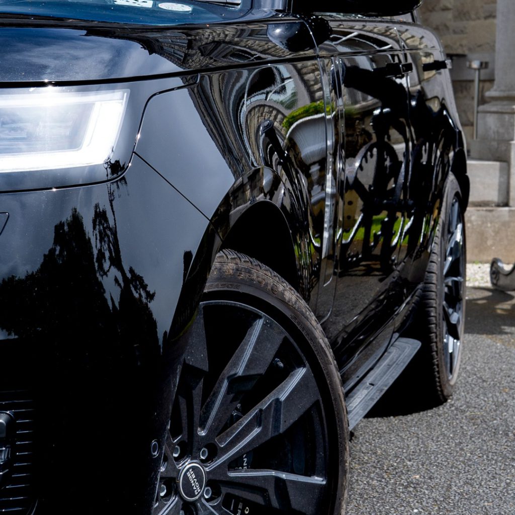 VIP Buses Black Range Rover Vogue SWB low angle of the front wheel beside the portico columns