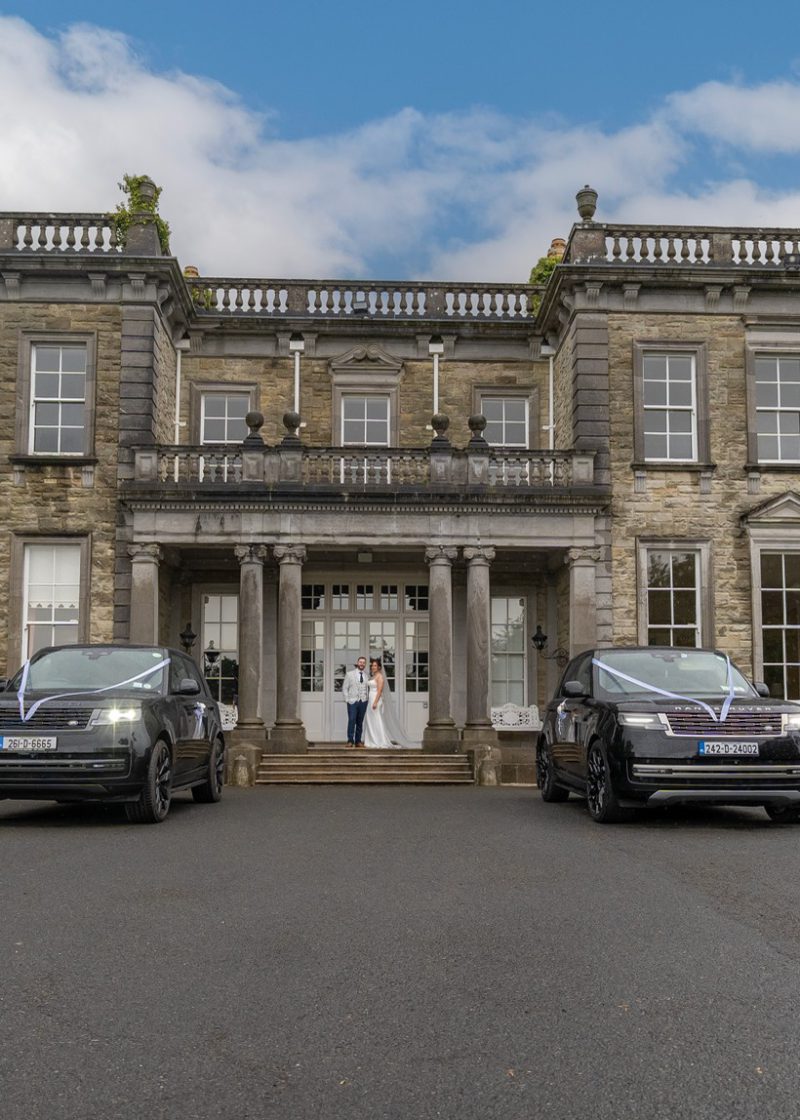 VIP Buses Black Range Rover Vogue SWB pair ribboned as the couple stand at the door