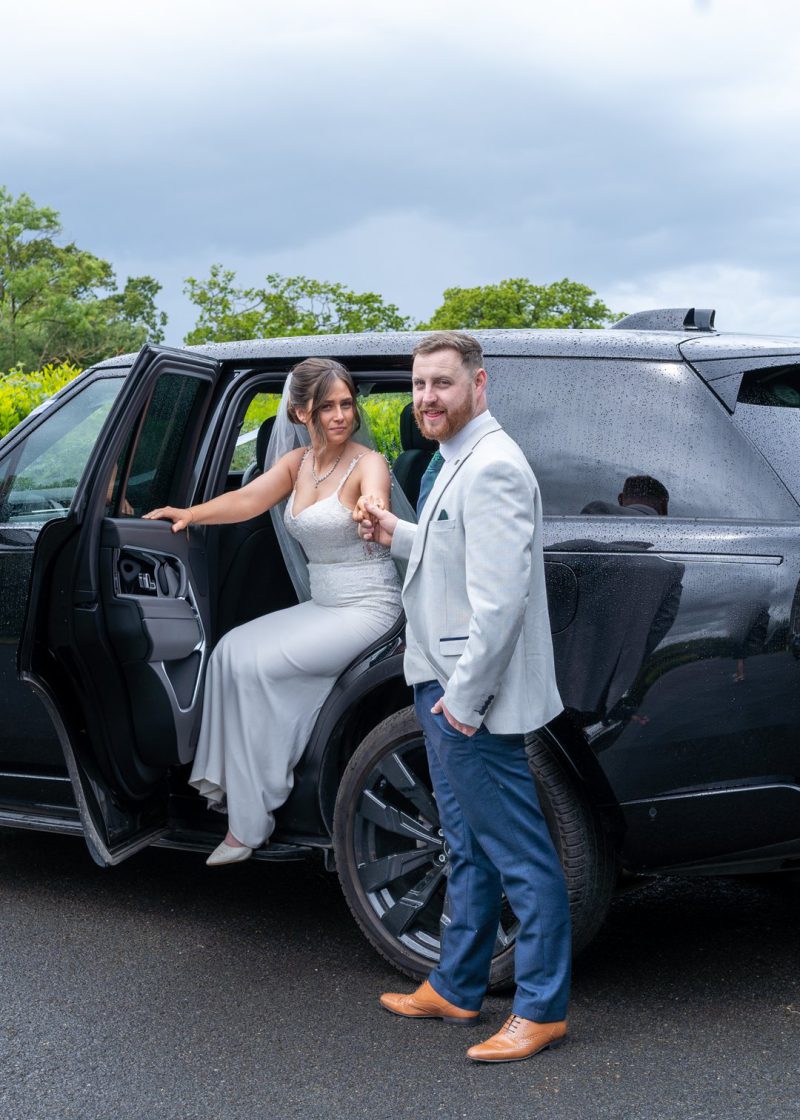 VIP Buses Black Range Rover Vogue SWB with the bride stepping out as the groom leads her hand
