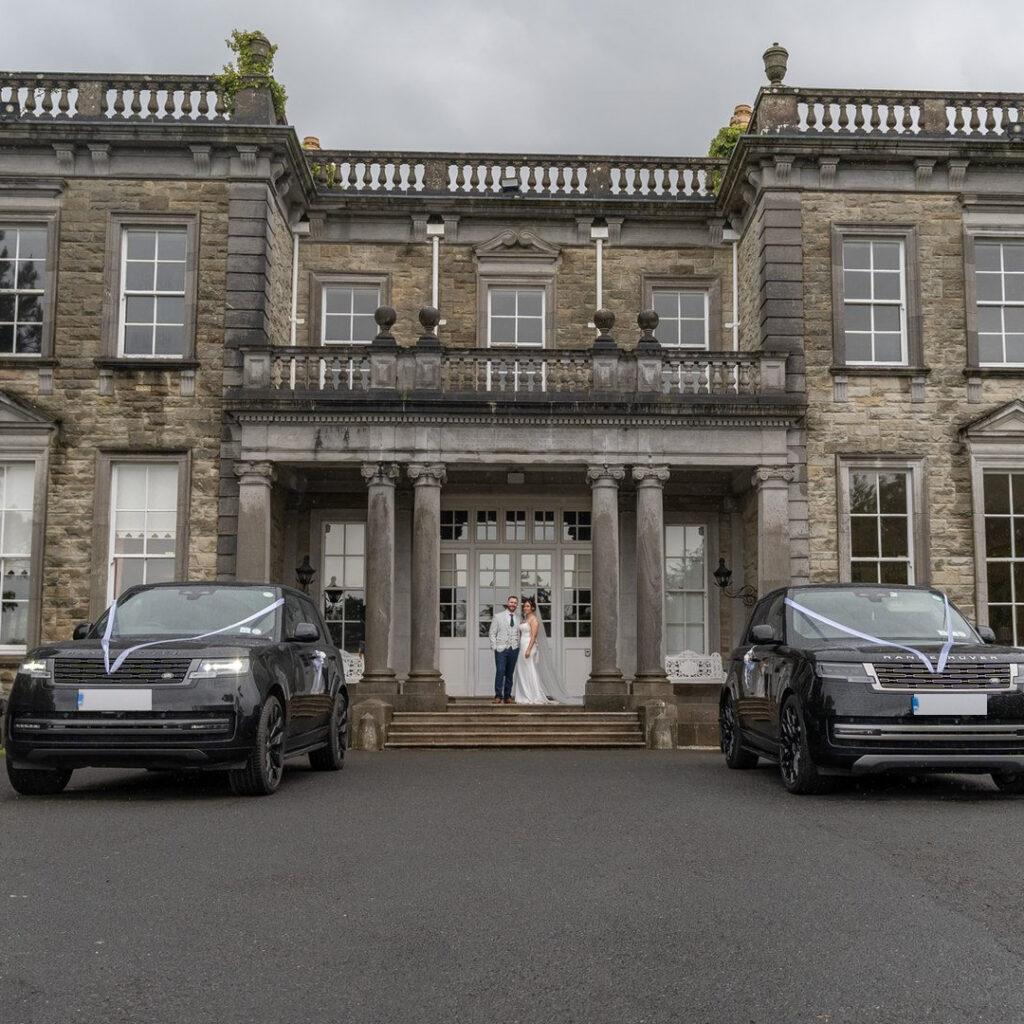 VIP Buses Black Range Rover Vogue SWB with the couple at the steps between the ribboned cars