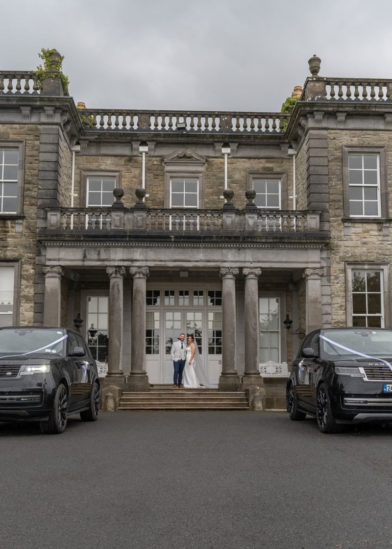 VIP Buses Black Range Rover Vogue SWB with the couple at the steps between the ribboned cars