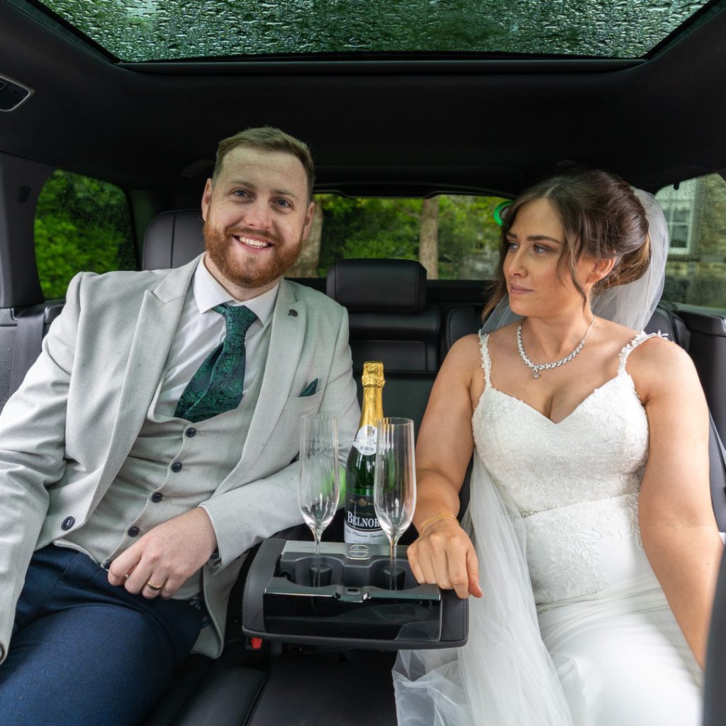 VIP Buses Black Range Rover Vogue SWB with the couple in the rear seats and champagne poured