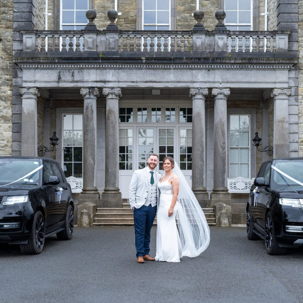 VIP Buses Black Range Rover Vogue SWB with the couple standing between the two ribboned cars