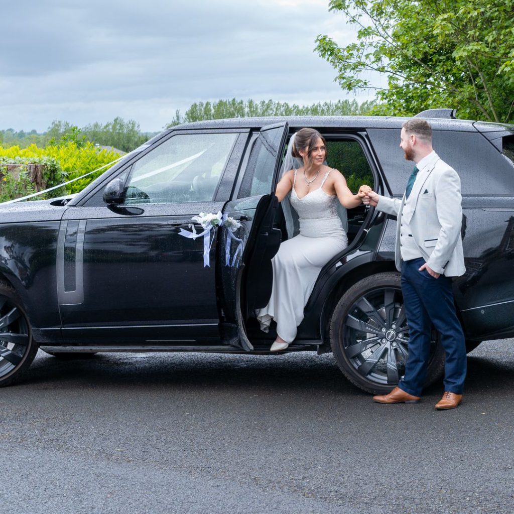 VIP Buses Black Range Rover Vogue SWB with the groom helping the bride out on a country drive
