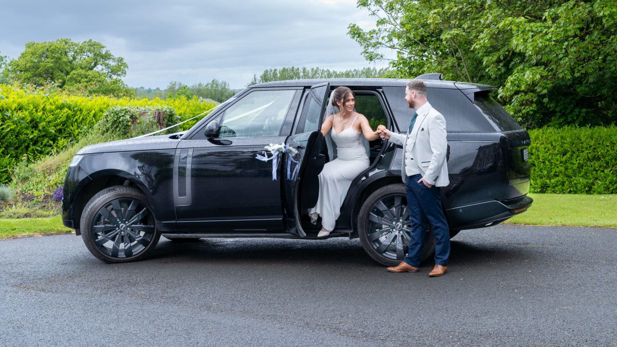 VIP Buses Black Range Rover Vogue SWB with the groom helping the bride out on a country drive