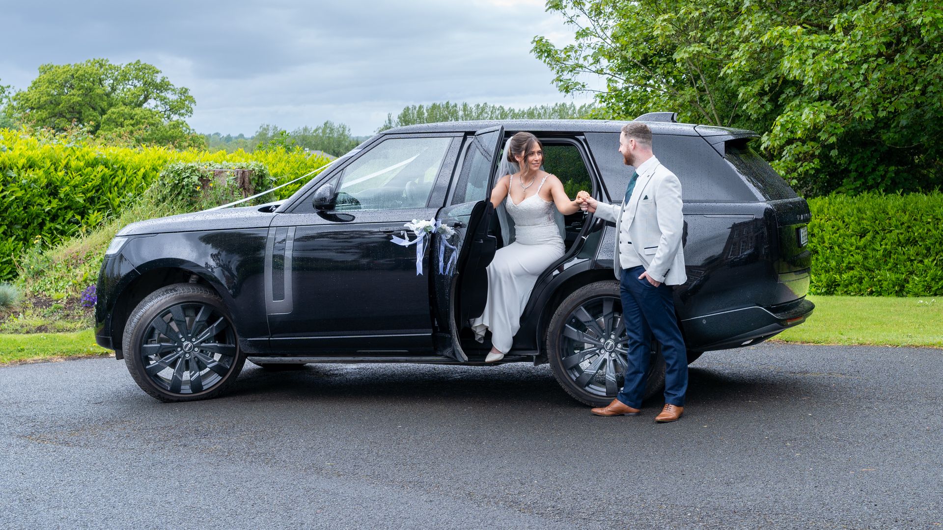 VIP Buses Black Range Rover Vogue SWB with the groom helping the bride out on a country drive