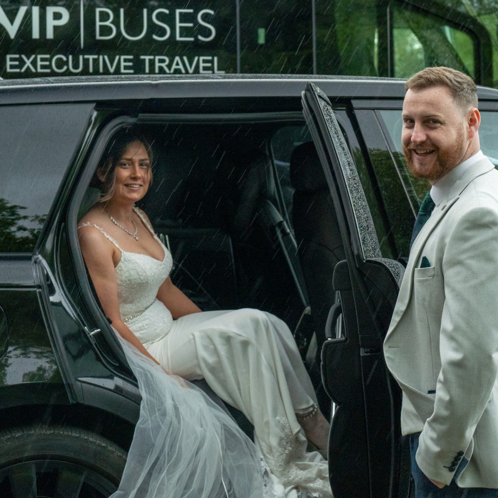 VIP Buses Black Range Rover Vogue SWB with the groom holding the door for the bride