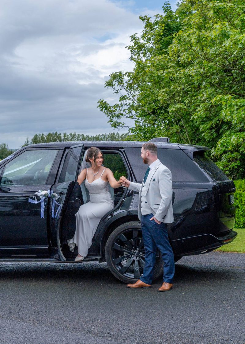VIP Buses Black Range Rover Vogue SWB with the groom taking the brides hand as she steps out