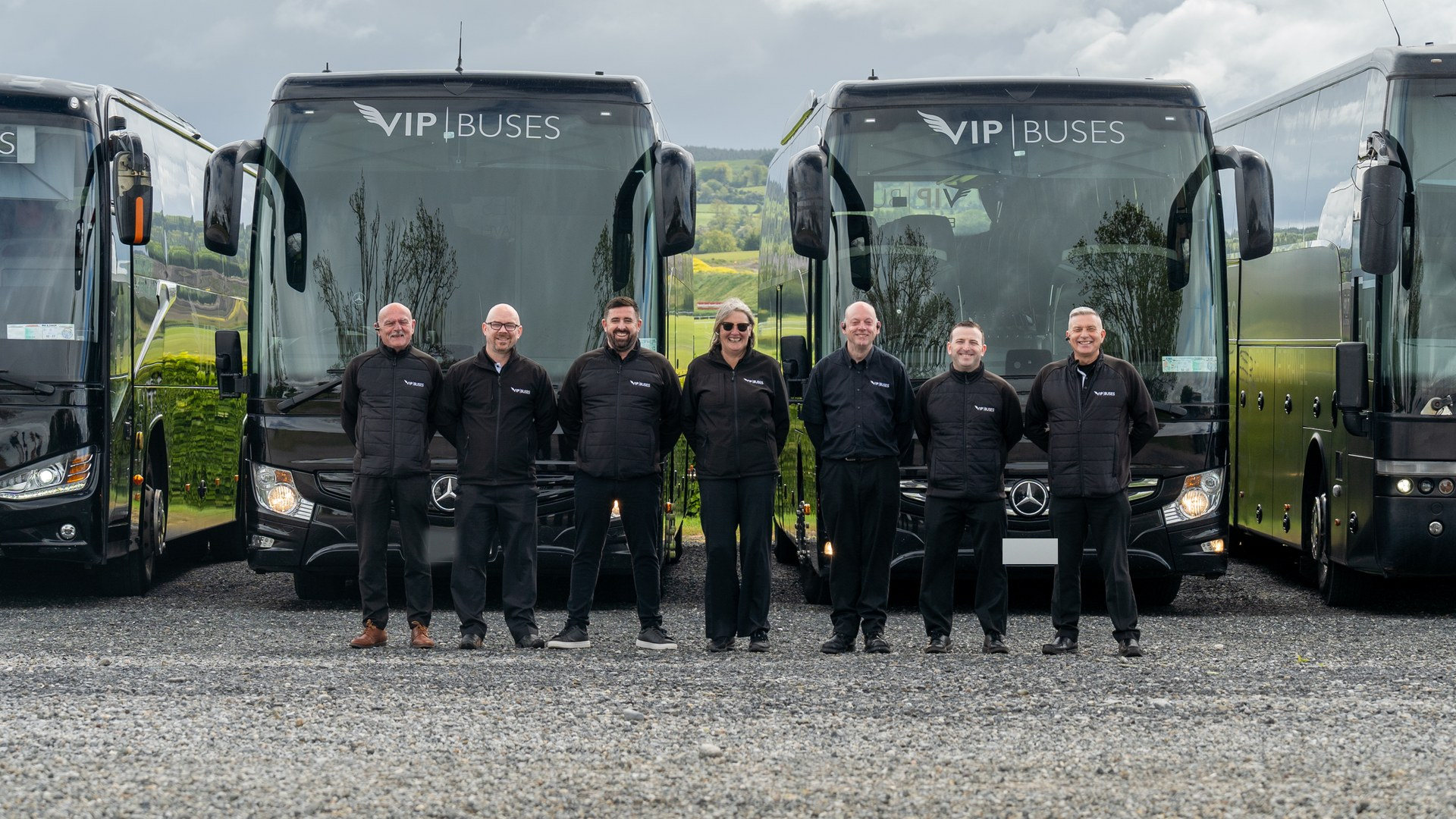 VIP Buses Fleet Lineup seven uniformed staff lined up in front of the fleet