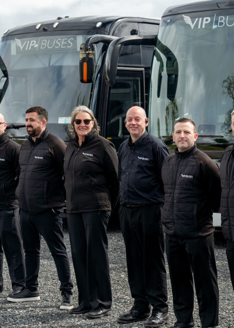 VIP Buses Fleet Lineup seven uniformed staff standing at an angle before the fleet