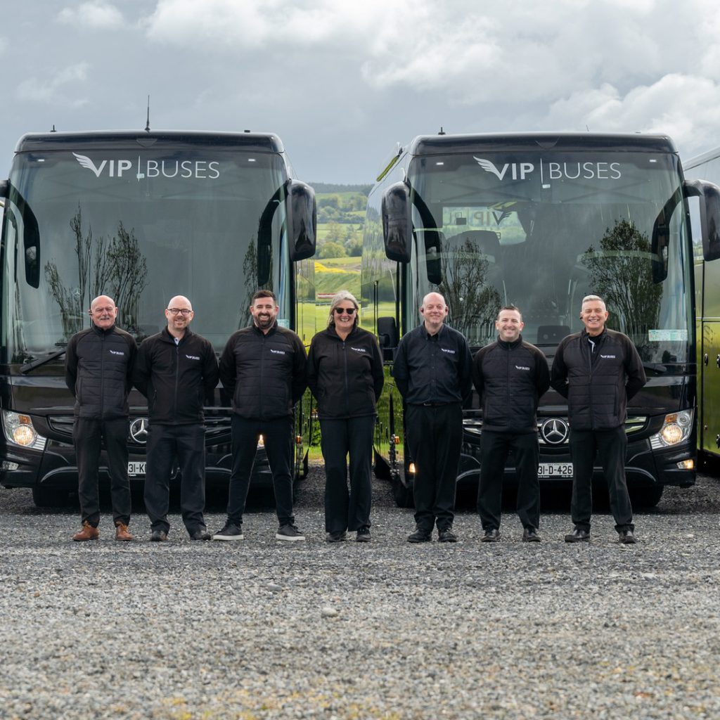 VIP Buses Fleet Lineup seven uniformed staff with green countryside behind them