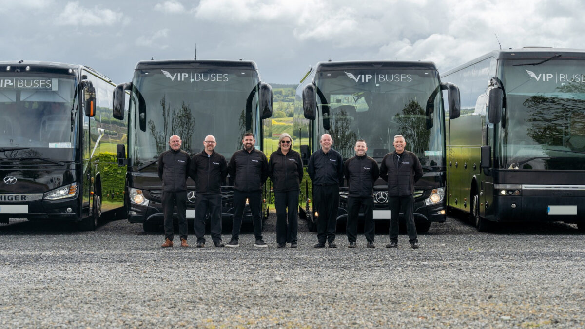 VIP Buses Fleet Lineup seven uniformed staff with green countryside behind them