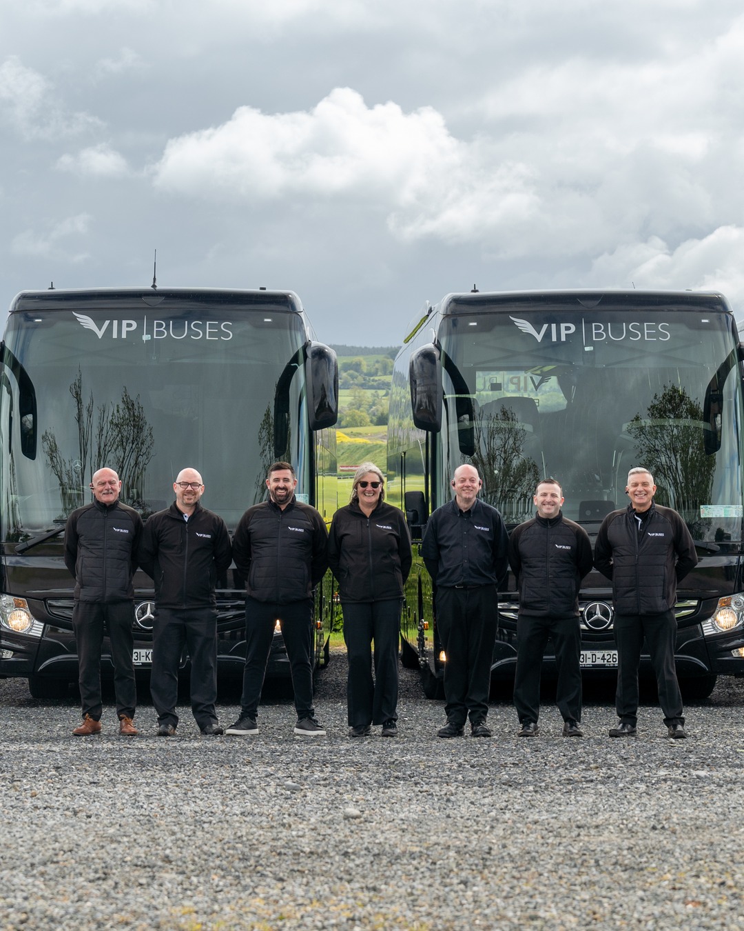 VIP Buses Fleet Lineup seven uniformed staff with green countryside behind them