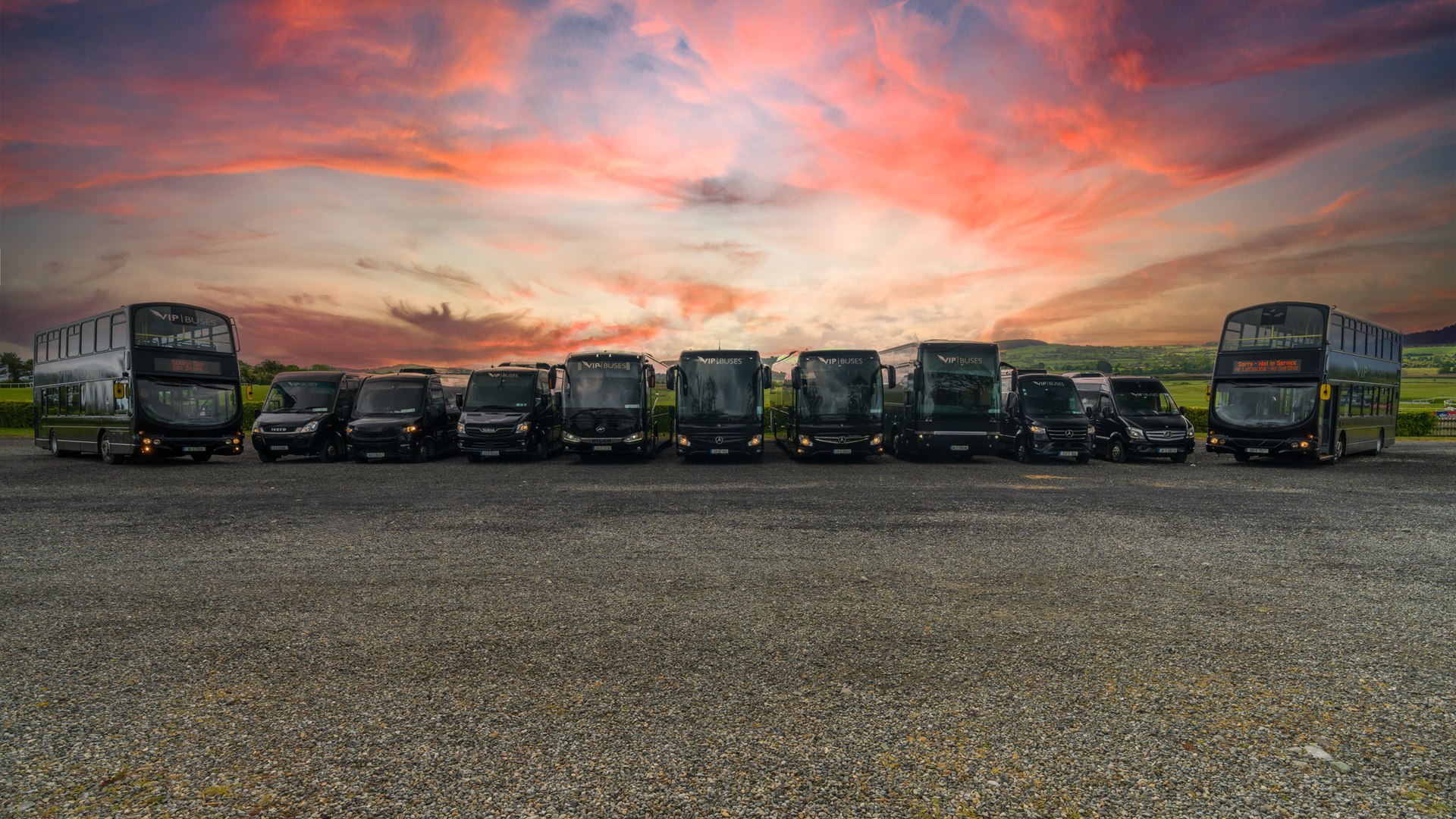 VIP Buses lineup the full lined up at the depot under a red sunset