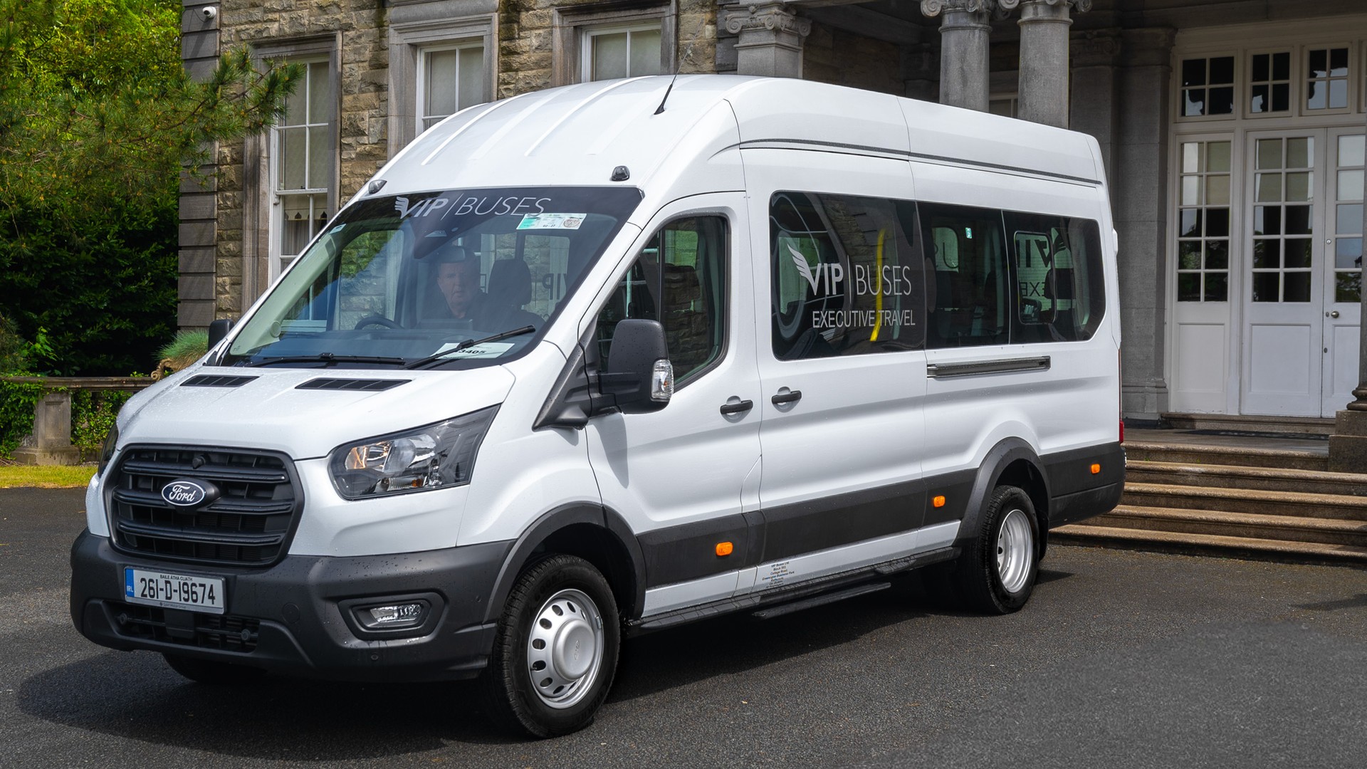 VIP Buses Ford Transit 17 Seater Minibus front three quarter below the house facade