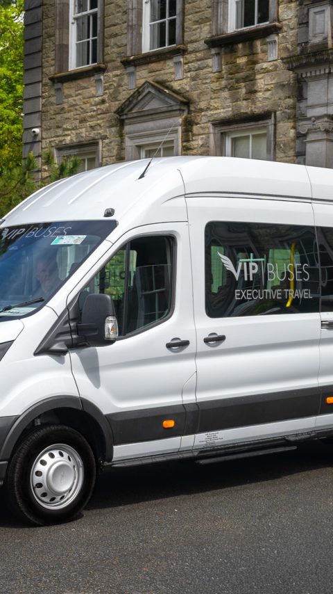 VIP Buses Ford Transit 17 Seater Minibus front three quarter with the driver at the wheel