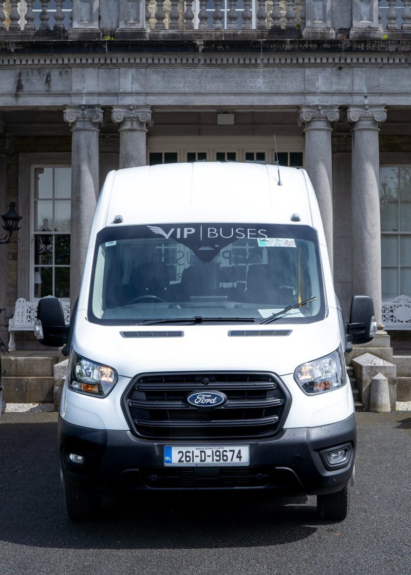 VIP Buses Ford Transit 17 Seater Minibus head on between two cannons at the entrance