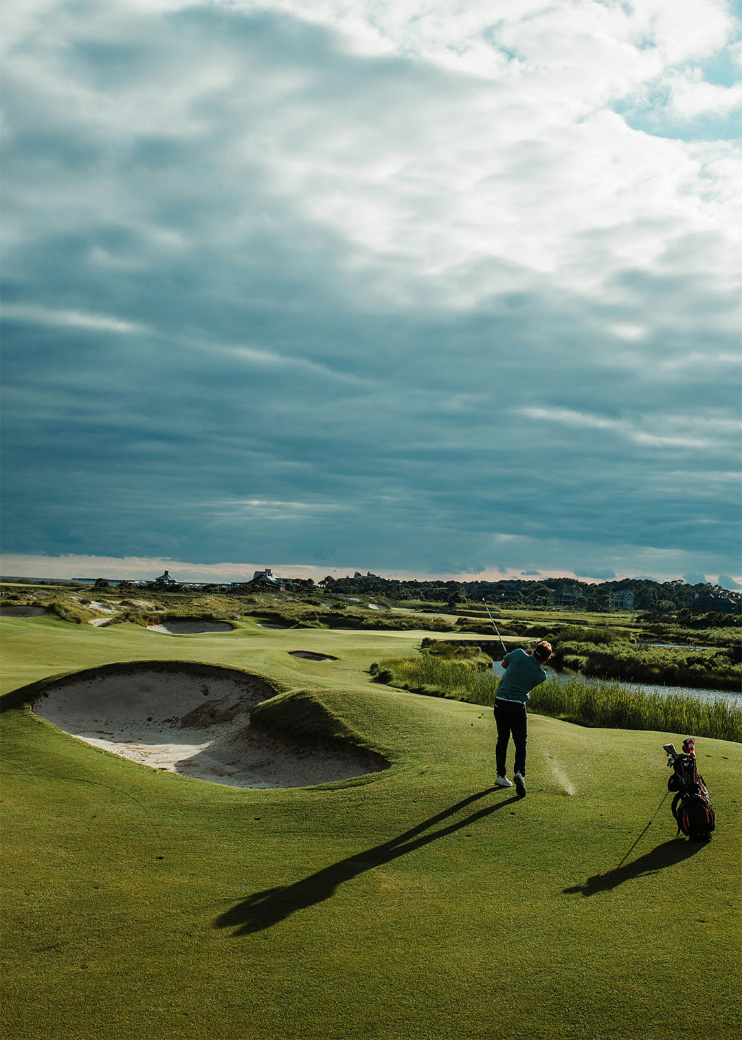 Golf trip golfer mid swing on a links fairway under a cloudy sky