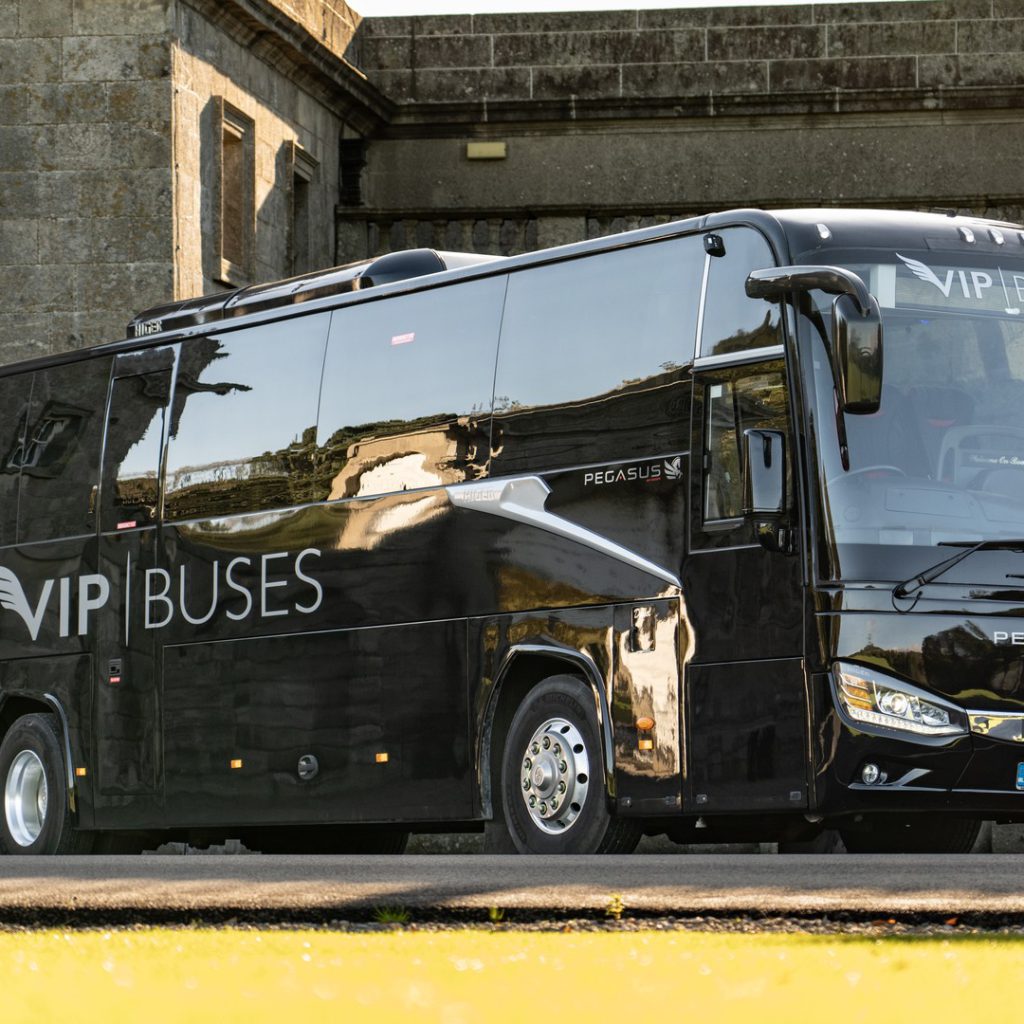 VIP Buses Higer 43 Seater Coach parked side on against the stone wall of a fort