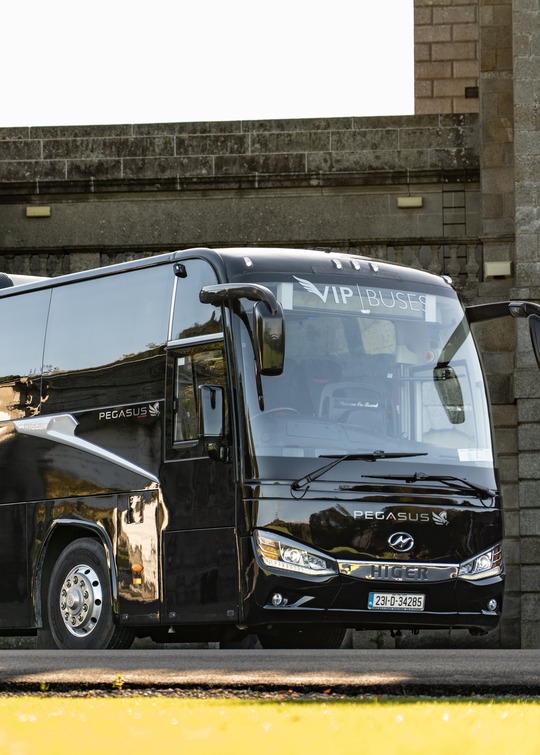 VIP Buses Higer 43 Seater Coach parked side on against the stone wall of a fort