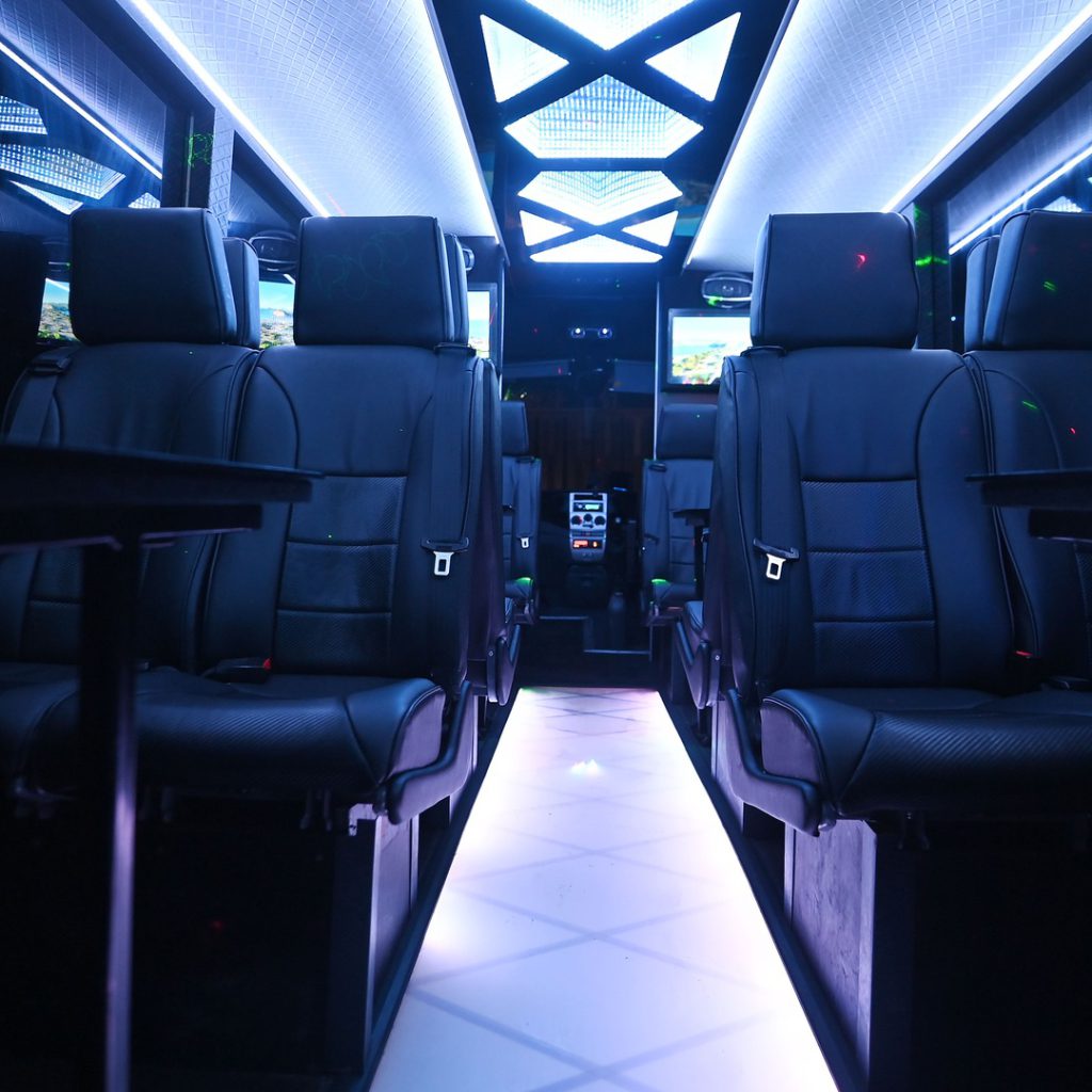 VIP Buses Iveco 16 Seater Party Bus cabin down the aisle under white ceiling light