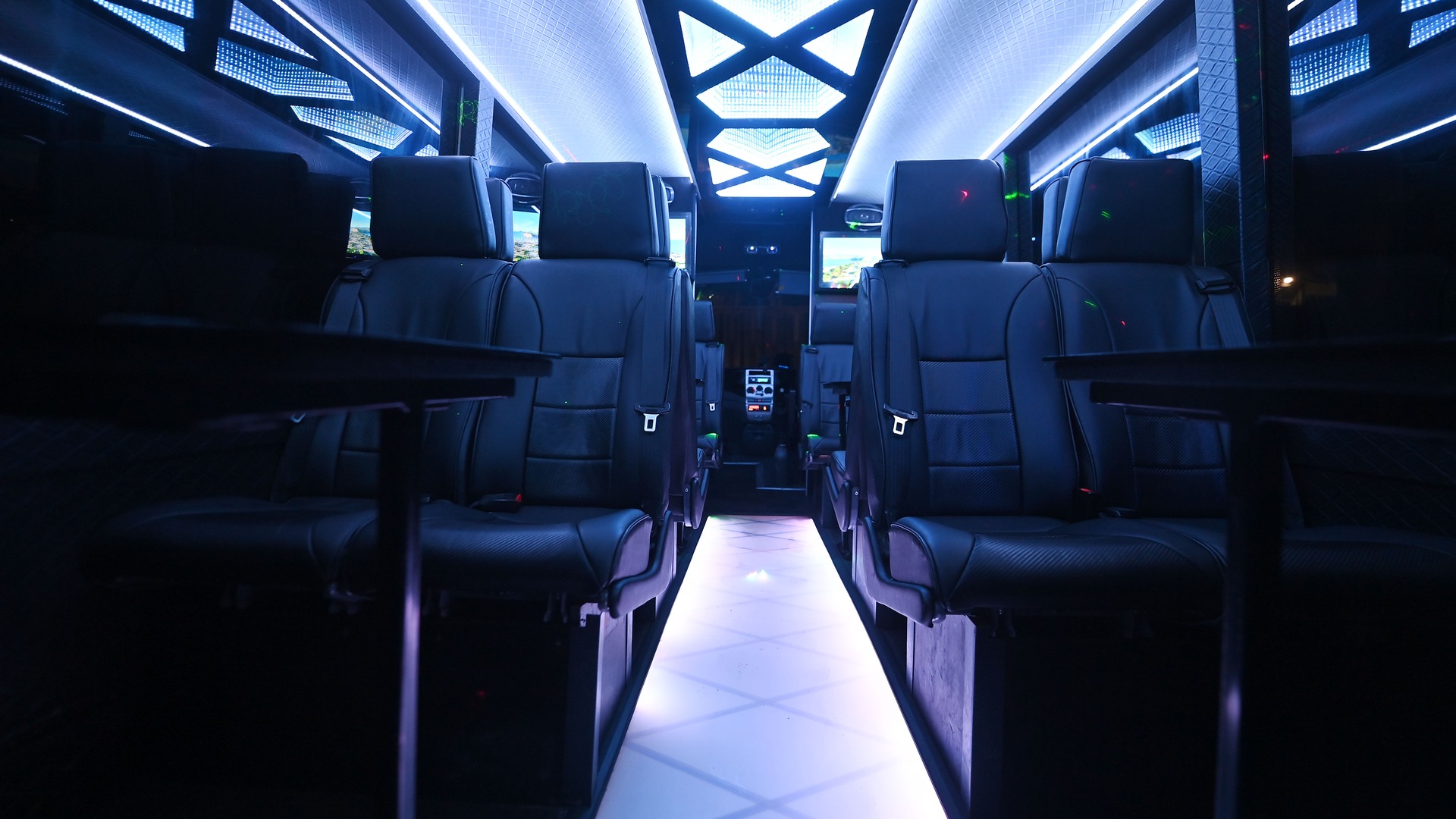 VIP Buses Iveco 16 Seater Party Bus cabin down the aisle under white ceiling light