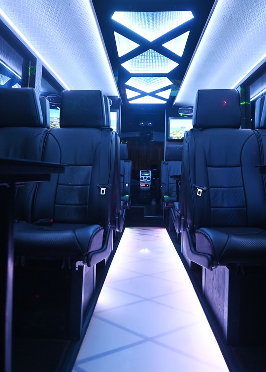 VIP Buses Iveco 16 Seater Party Bus cabin down the aisle under white ceiling light