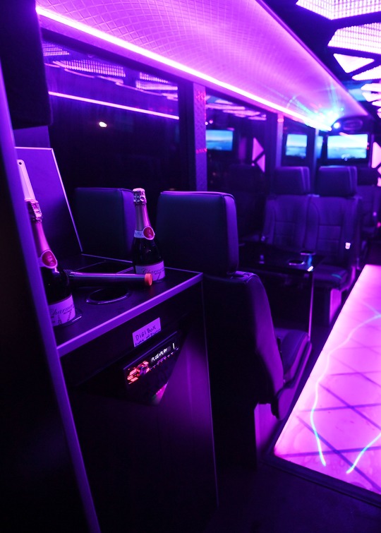 VIP Buses Iveco 16 Seater Party Bus console with bottles at the left lit aisle running away to the right