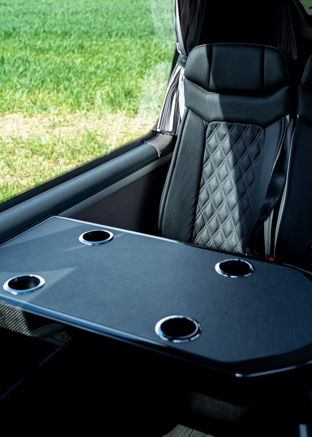 VIP Buses Mercedes Sprinter 16 Seater Minibus carbon fibre table beside a quilted seat