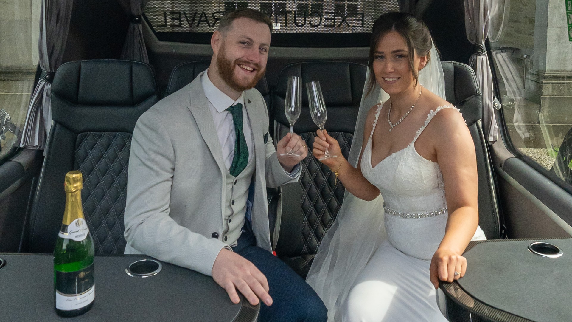 VIP Buses Mercedes Sprinter 16 Seater Minibus interior with the couple smiling with champagne