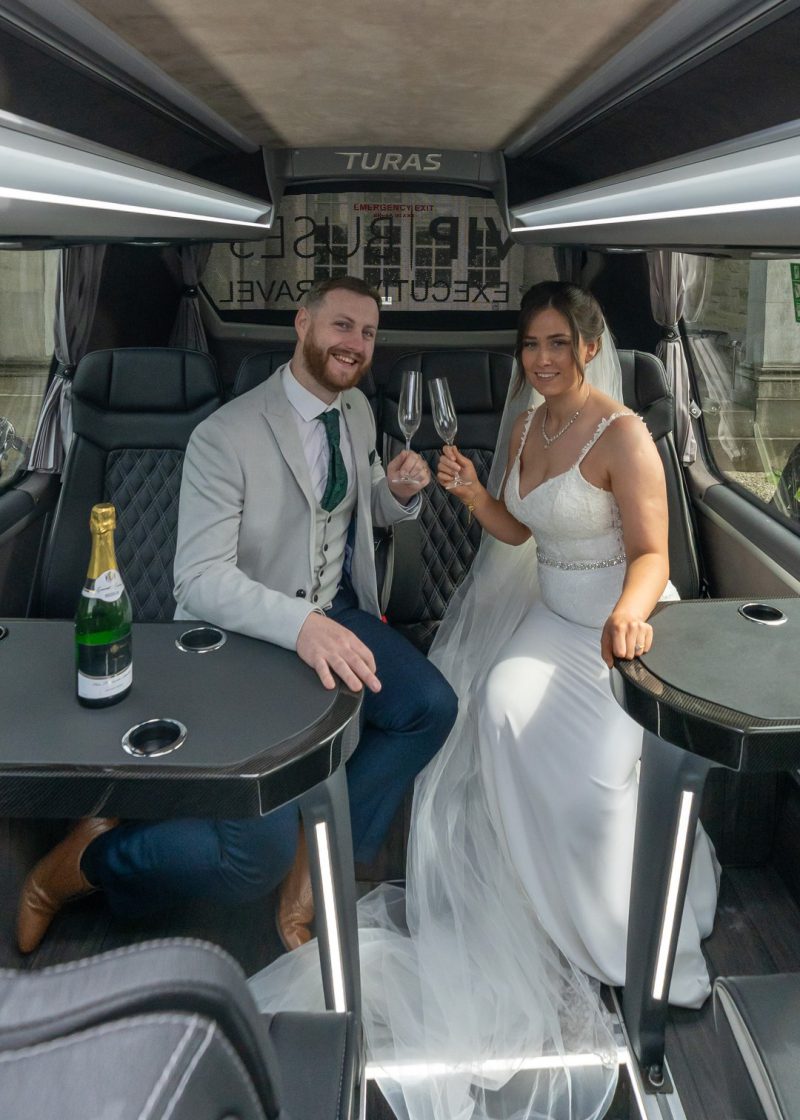 VIP Buses Mercedes Sprinter 16 Seater Minibus interior with the couple smiling with champagne