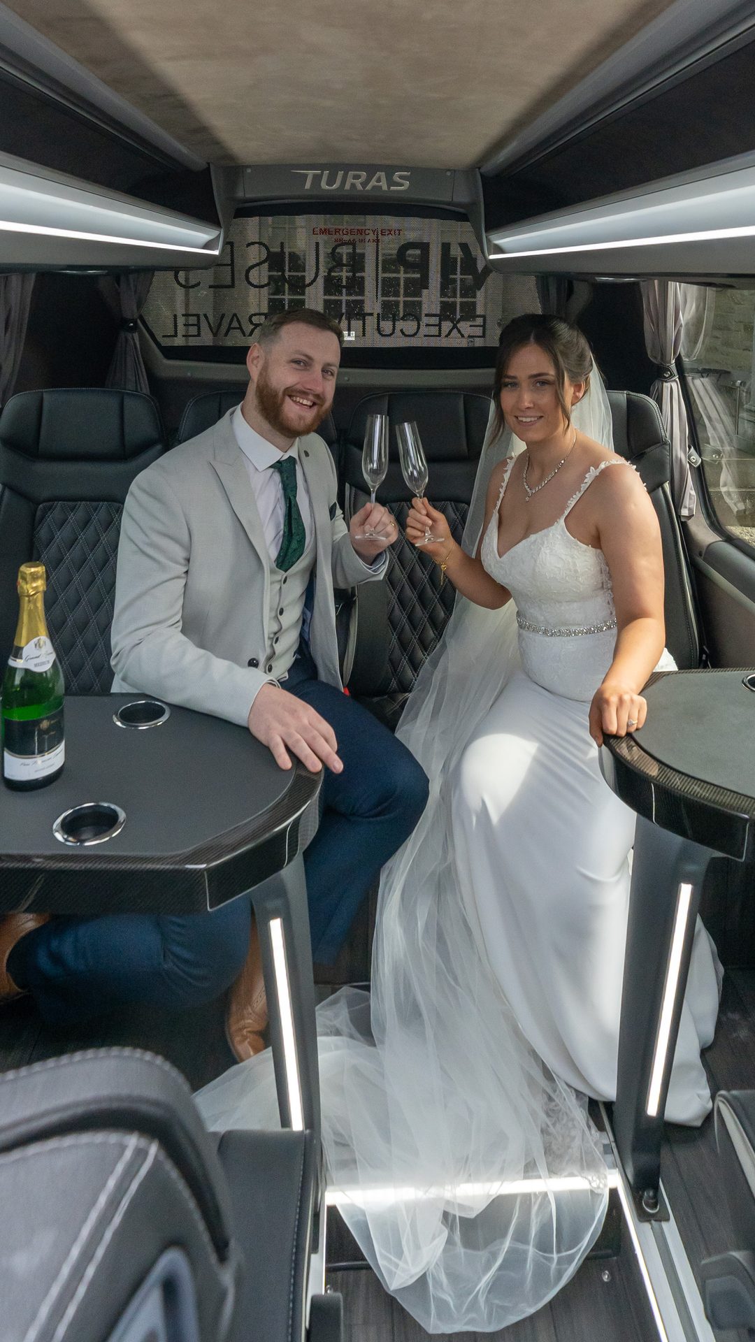 VIP Buses Mercedes Sprinter 16 Seater Minibus interior with the couple smiling with champagne