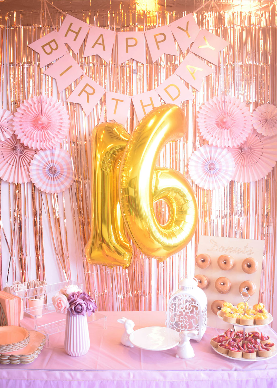Teen birthday party gold 16 balloons and a donut wall at a pink dessert table