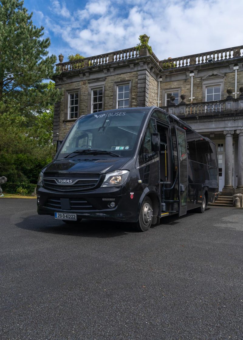 VIP Buses Turas 33 Seater Coach front three quarter with the door open by the portico